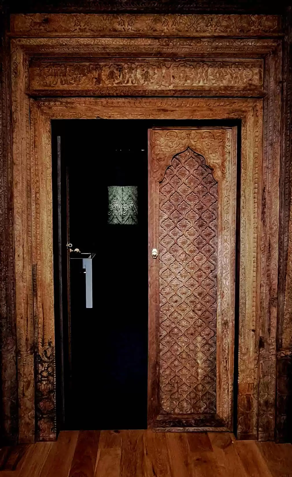 Interior view of Islamic art gallery, featuring carved Islamic doors and a flexible exhibition layout.